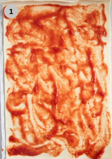 spreading tomato sauce on a sheet of puff pastry.