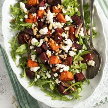 beetroot and sweet potato salad with feta and arugula on a platter.