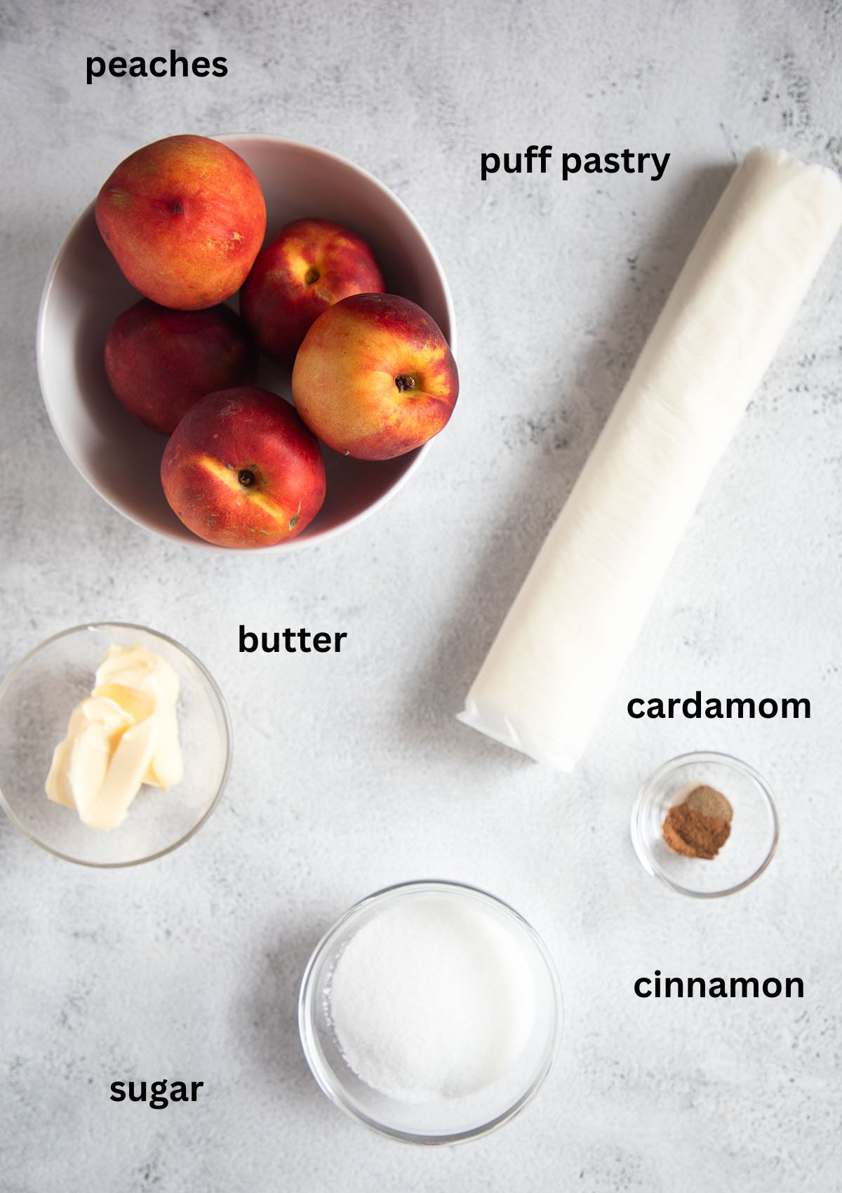 listed ingredients for making tarte tatin with peaches, puff pastry, butter, sugar and spices.