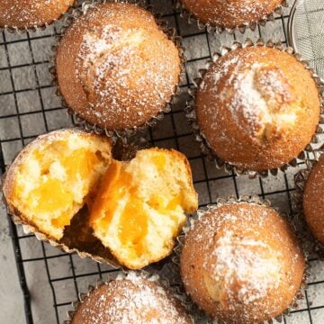 mandarin muffins, one split to show the fruit inside.