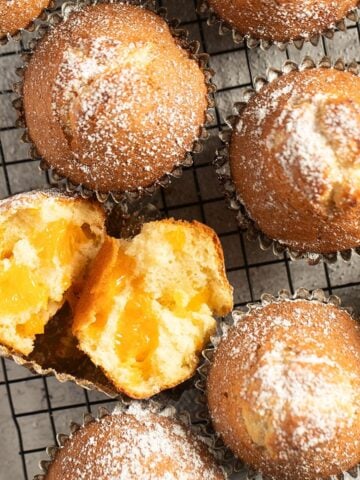 mandarin muffins, one split to show the fruit inside.