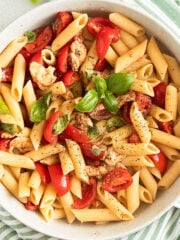 penne caprese with tomatoes, mozzarella and fresh basil in a bowl.