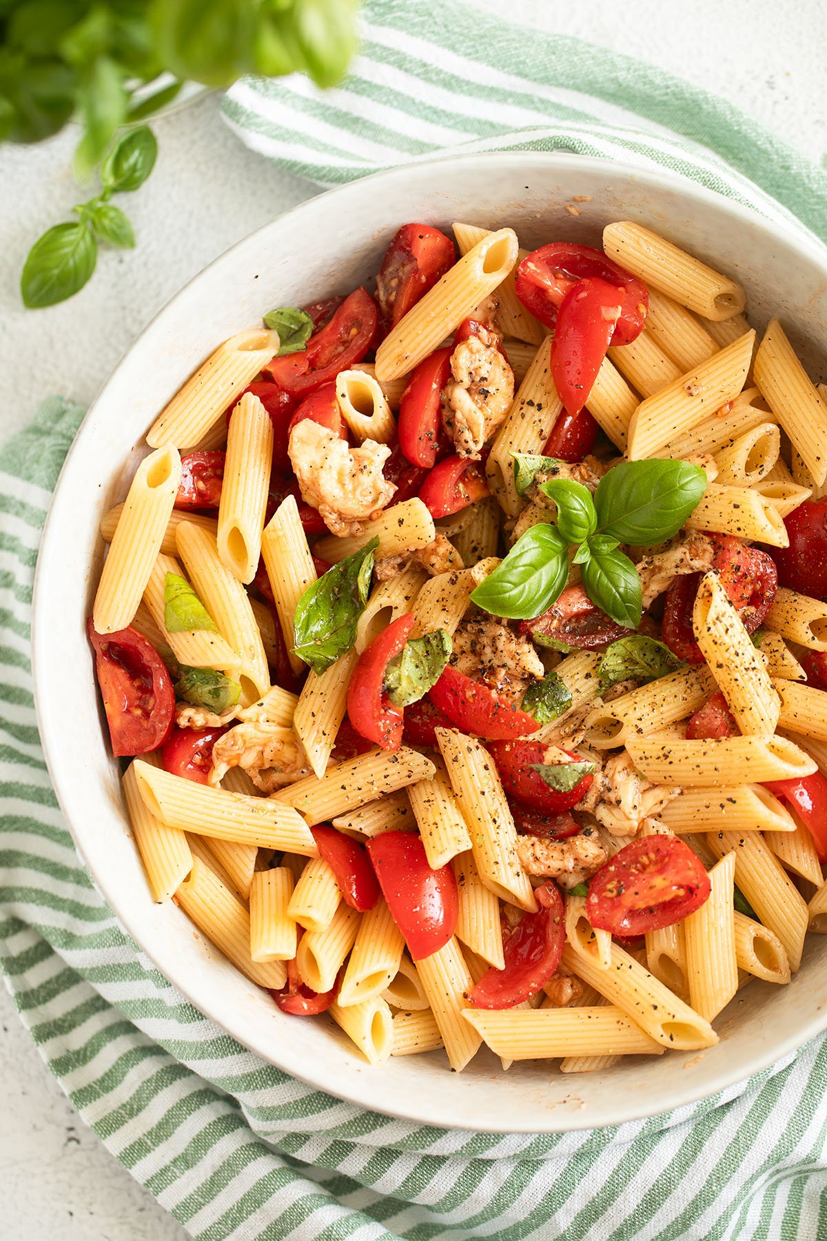 pasta caprese with tomatoes and mozzarella in a large bow.