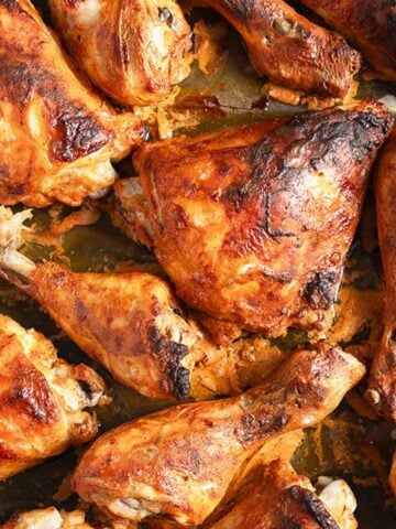 tandoori paste chicken pieces on a baking tray.