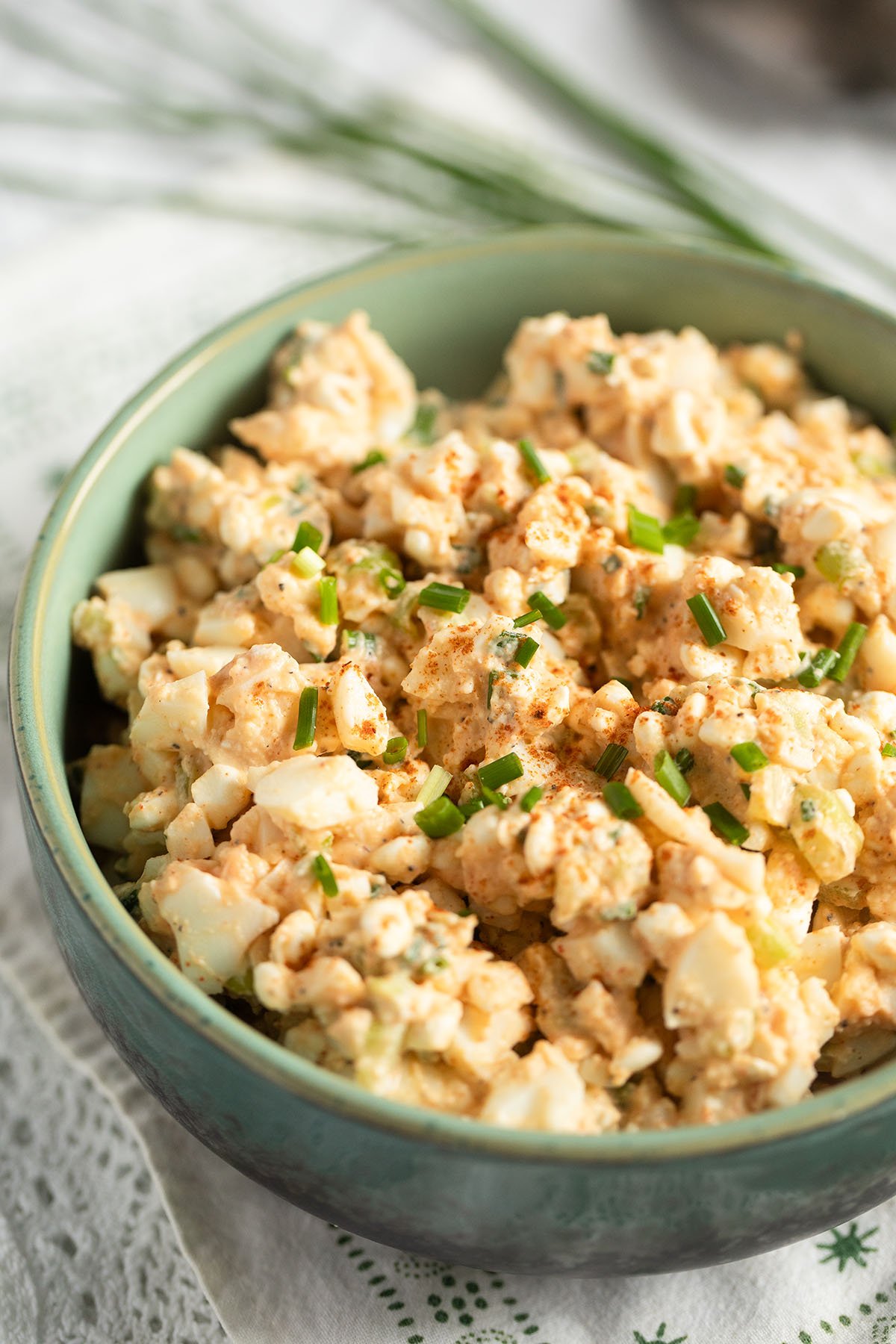 bowl with chunky egg salad with cottage cheese, avocado and chives.