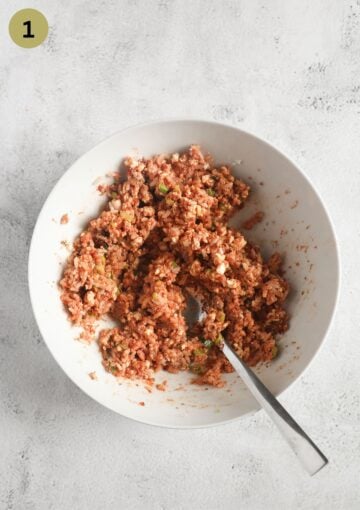 mixing rice with tomato paste and spice for making filling for zucchini in a small bowl.