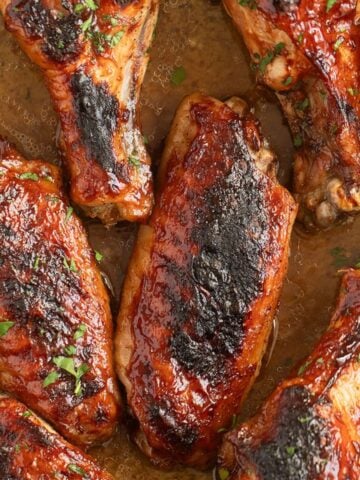 many crispy baked turkey wings sprinkled with fresh parsley.