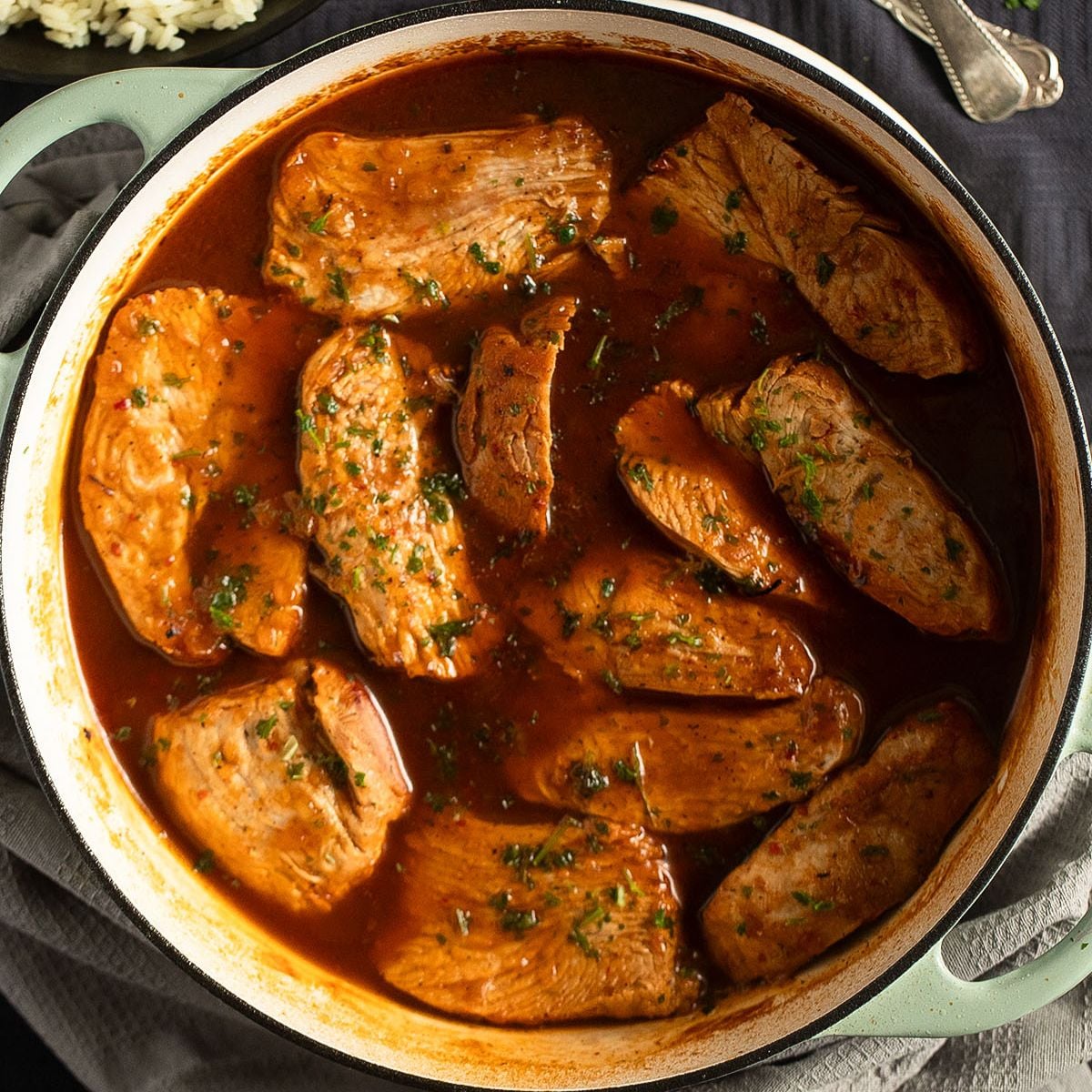 sliced turkey breast with sauce in a dutch oven.