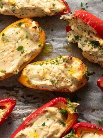 red and yellow cream cheese stuffed peppers sprinkled with parsley.