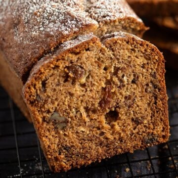 banana raisin bread slice leaning on the rest of the loaf.