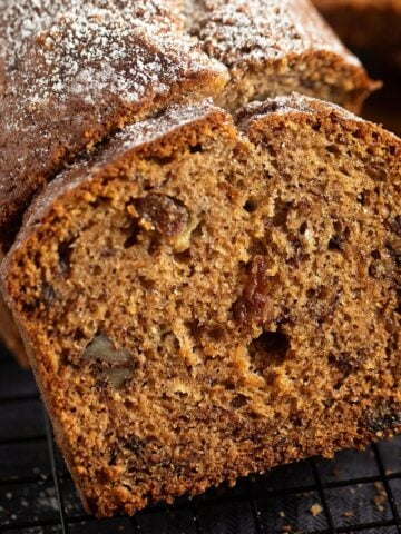 banana raisin bread slice leaning on the rest of the loaf.