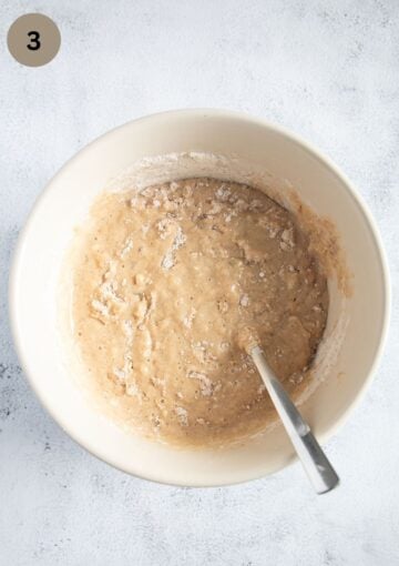 folding dry ingredients into the bread batter with a spoon.