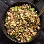 quinoa and salmon salad topped with avocado and feta in a bowl.