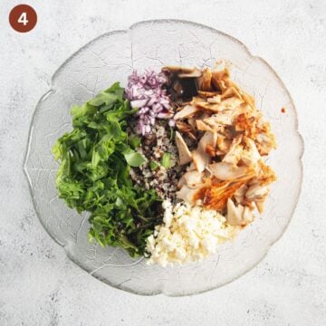 chopped ingredients for making salad with quinoa, salmon, and arugula in a bowl.