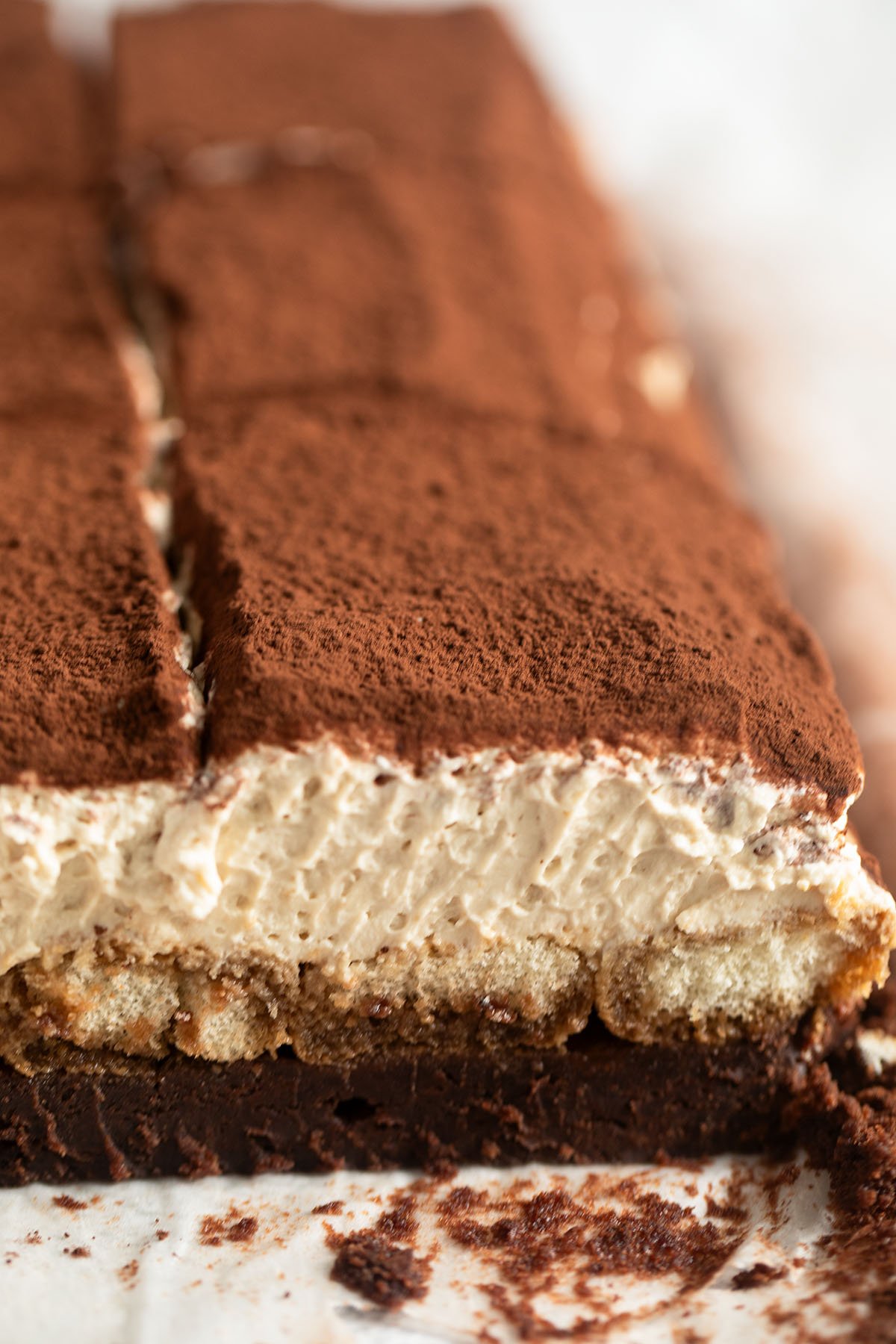 one large piece of tiramisu brownie cut to show the creaminess and the layers.