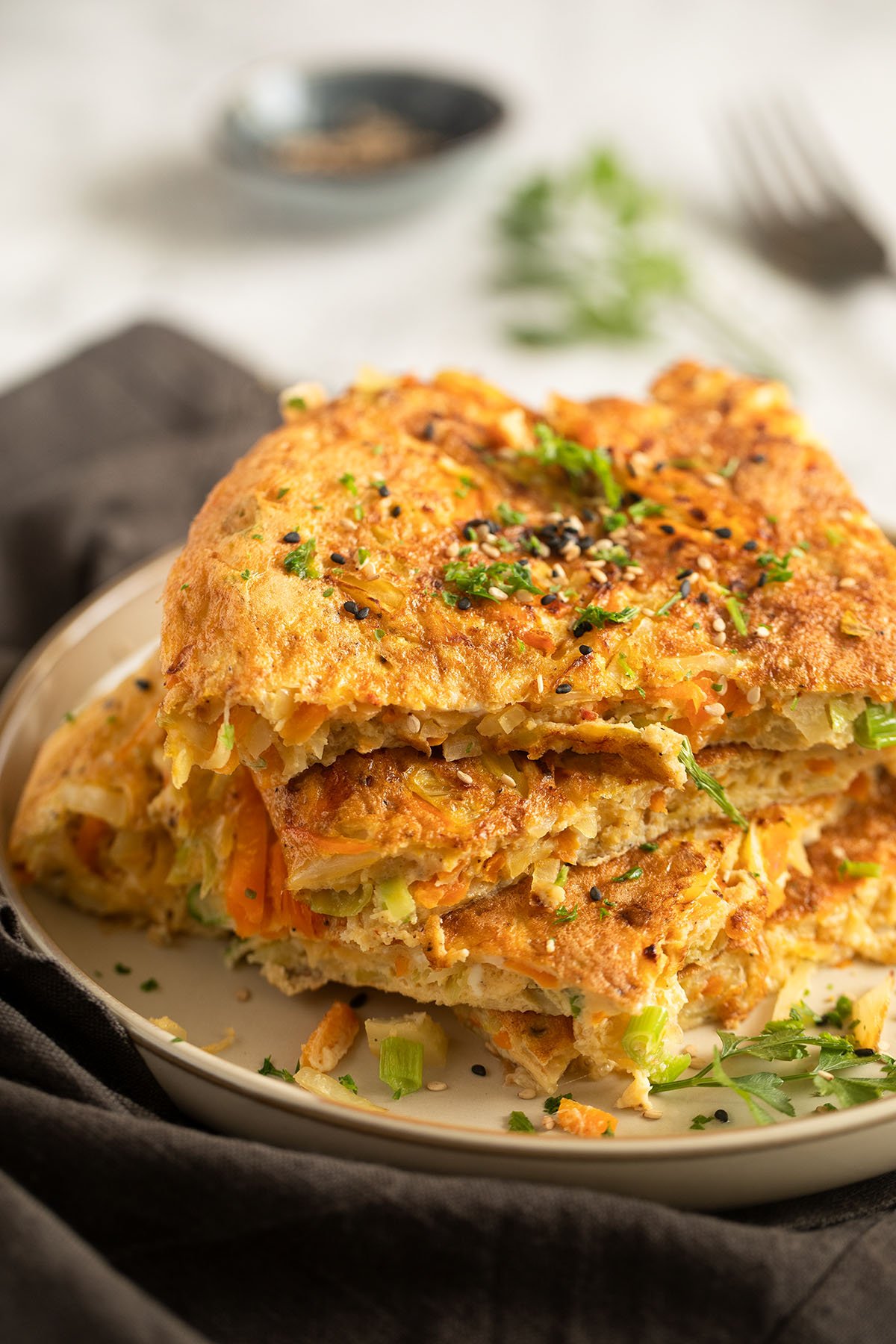 sliced cabbage omelet stapled on a plate.