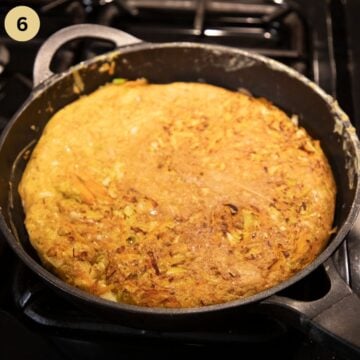 omelet with cabbage and cheese in a pan after flipping it.