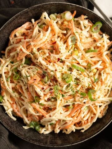 creamy celeriac coleslawe in a brown bowl.