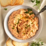 red pepper and feta dip sprinkled with parsley in a small bowl.