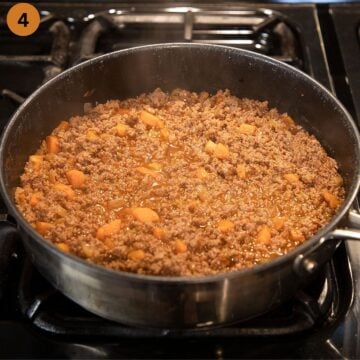 cooking the cottage pie fillling in a large saucepan on the stovetop.