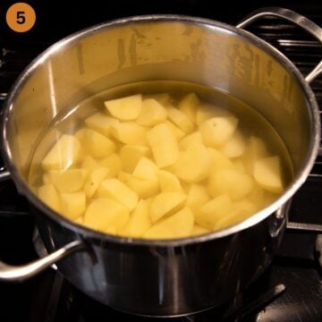 peeled and chopped potatoes covered with water in a pot on the stovetop.