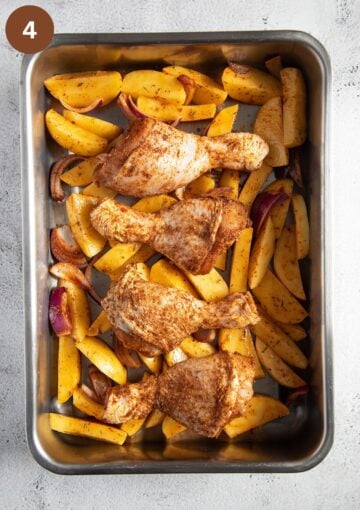 roasted potatoes, chicken drumsticks and onions in a baking pan.