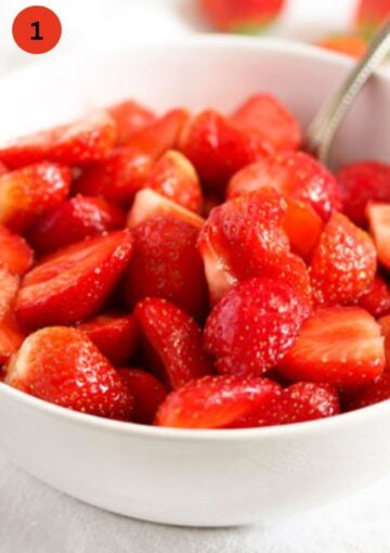 sliced strawberries marinating with sugar in a bowl 