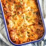 vegetable lasagna with bechamel sauce in a baking dish with blue rim.