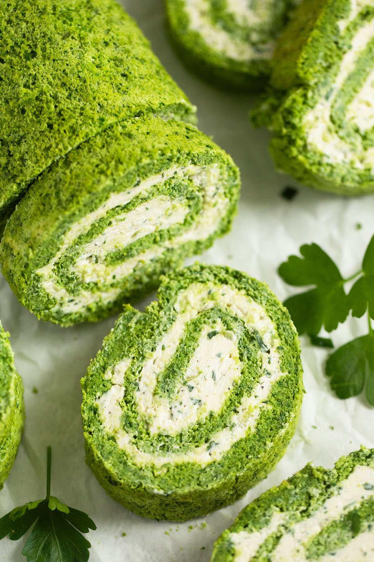 spinach roll filled with cream cheese thickly sliced on the table.