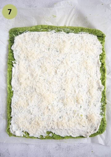 spreading cream cheese filling on spinach sheet to make a roulade.