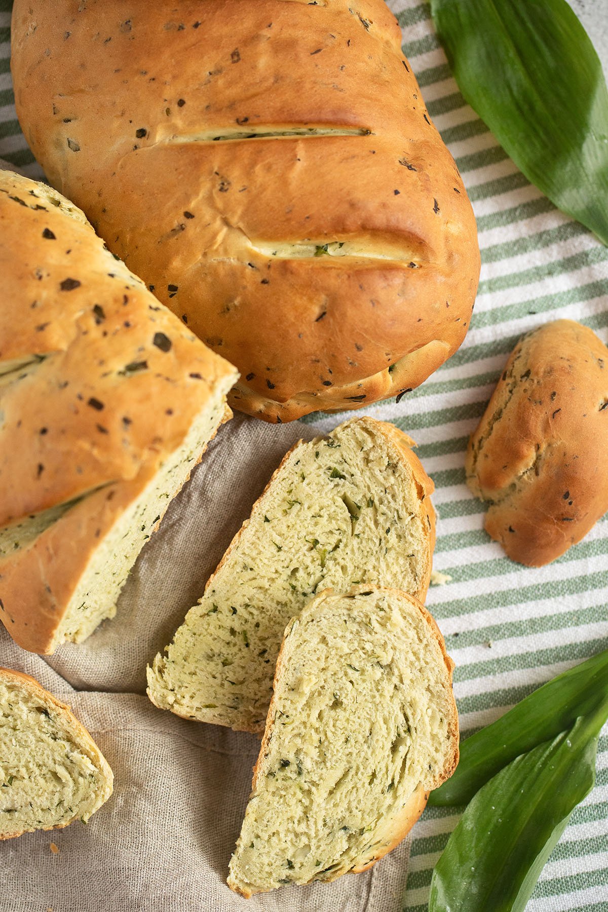 two pieces of wild garlic bread and many cut slices.