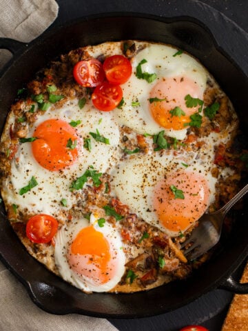 fisherman's eggs sprinkled with parsley in a cast iron skillet.