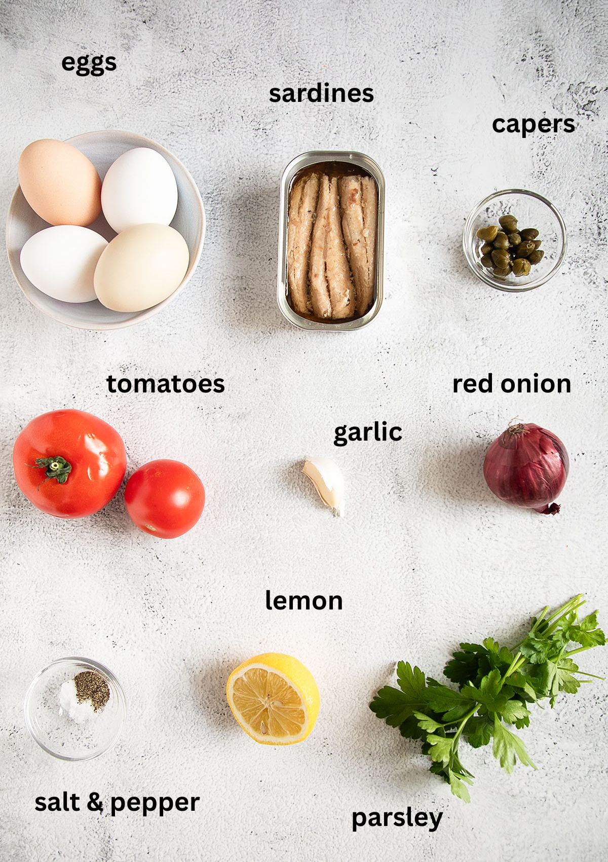 labeled ingredients for making eggs with sardines, tomatoes, lemon and parsley.