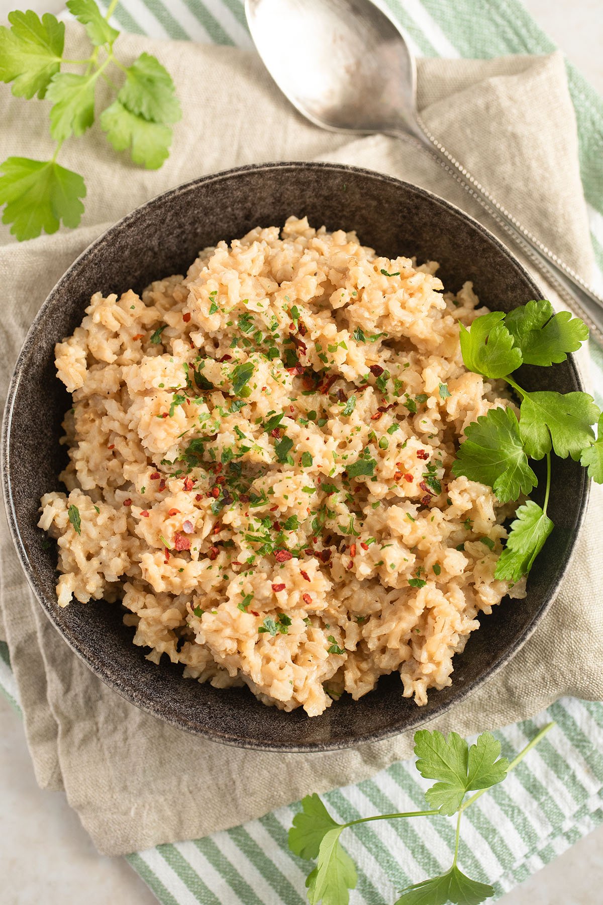 brown rice with miso topped with cilantro in a bowl on a kitchen towel.