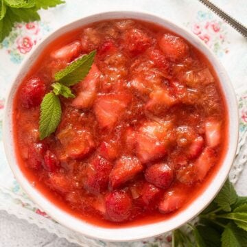 strawberry rhubarb compote garnished with mint in a bowl.