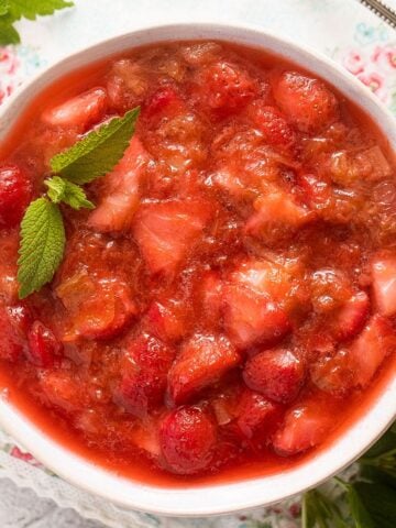 strawberry rhubarb compote garnished with mint in a bowl.