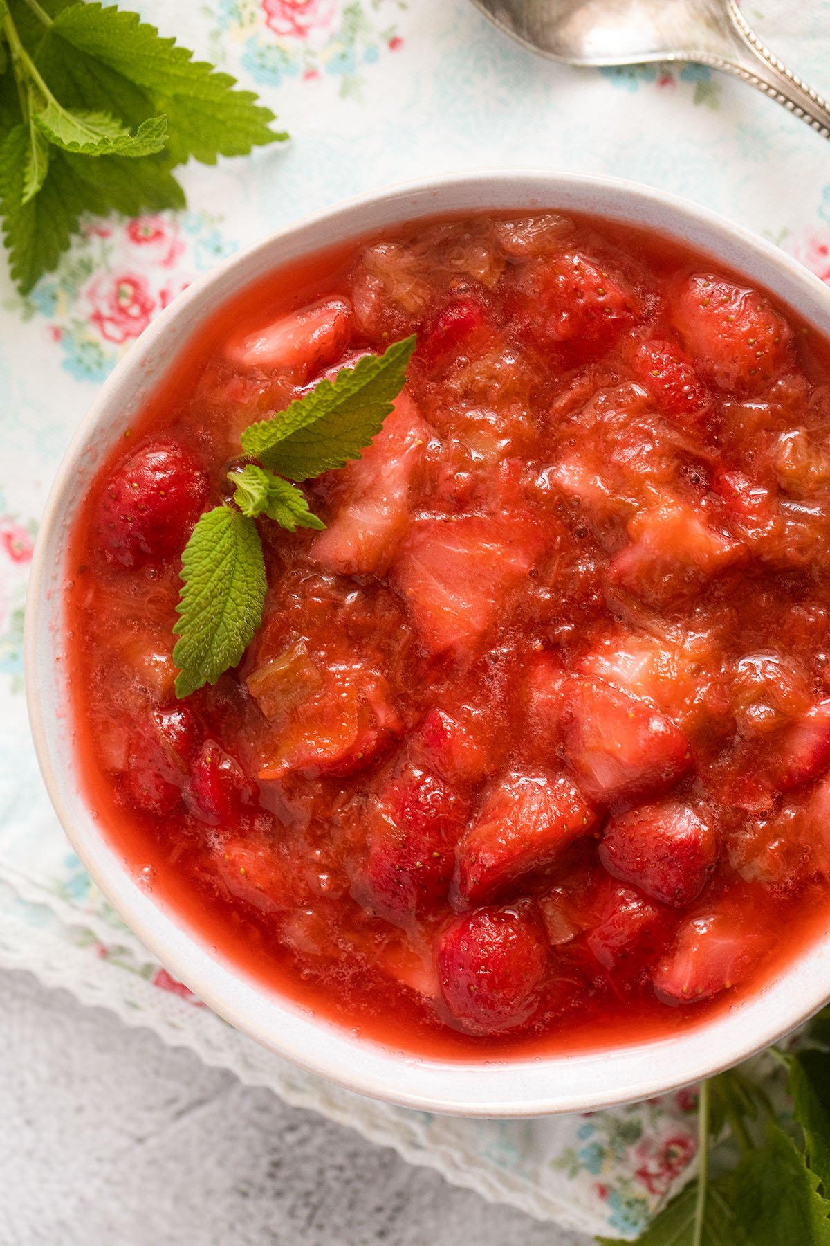 a bowl with rhubarb and strawberry compote garnished with mint.