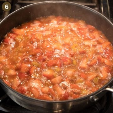 simmering compote with strawberries and rhubarb in a saucepan.