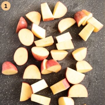 chopped red-skinned potatoes on a cutting board.