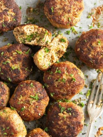 turkey and zucchini meatballs and a fork sprinkled with parsley.