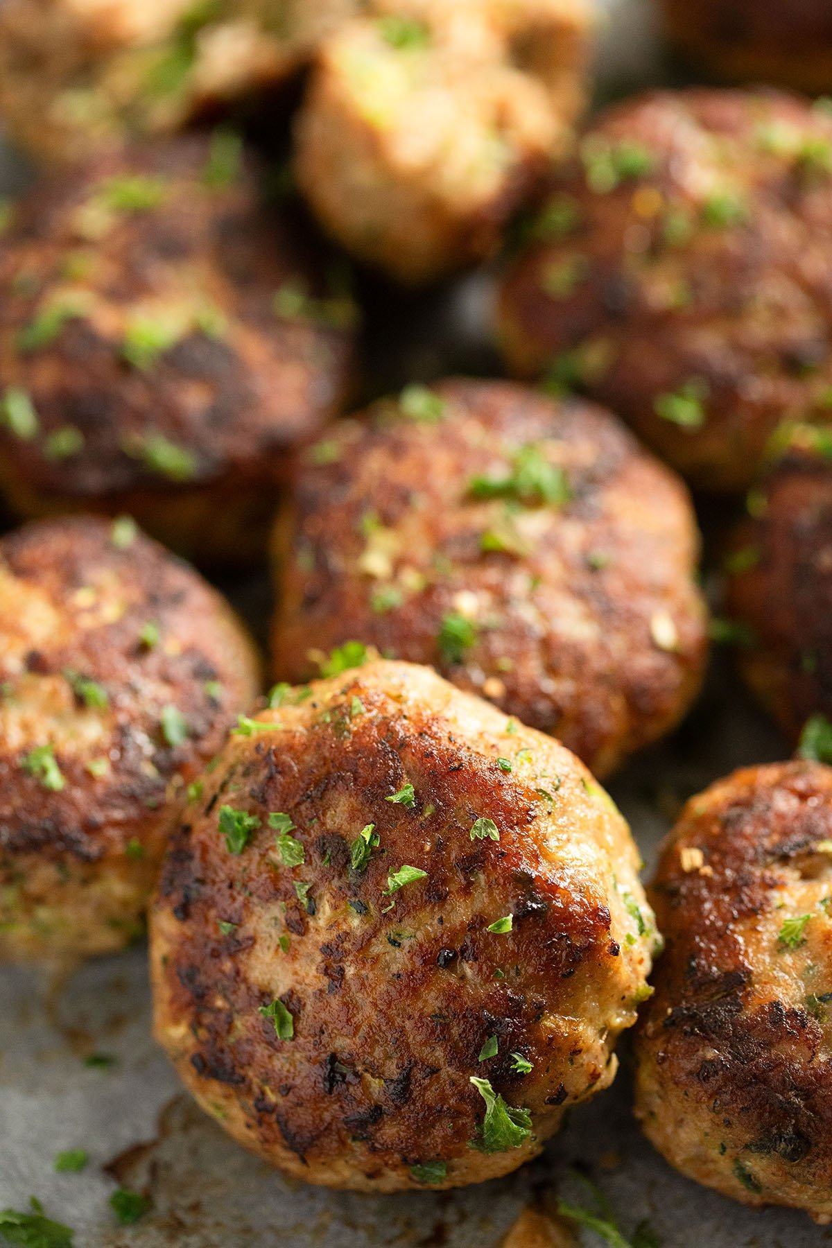 round and brown zucchini and turkey meatballs sprinkled with parsley.