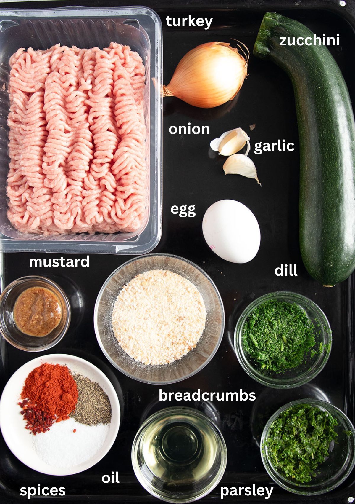 labeled ingredients for making meatballs with zucchini, breadcrumbs and herbs.