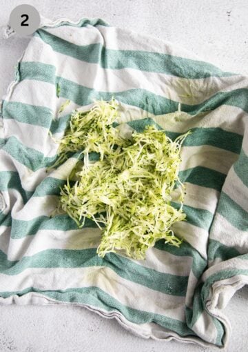 grated and squeezed zucchini on a kitchen cloth.