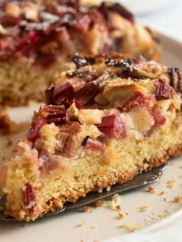 a slice of apple and rhubarb cake on a platter.