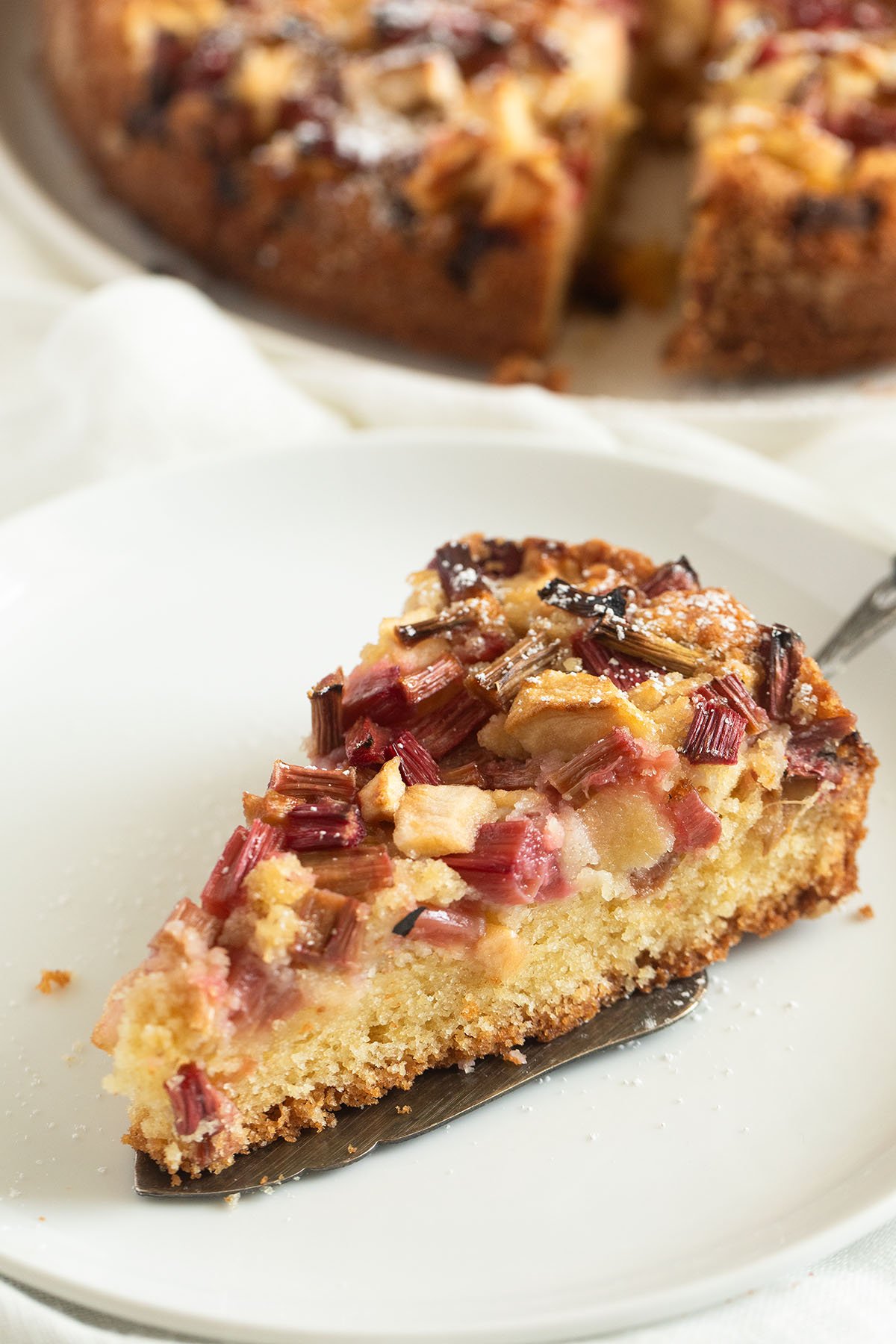 one slice of rhubarb cake with apples on a plate.