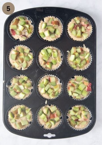unbaked muffins topped with rhubarb in a baking tin.