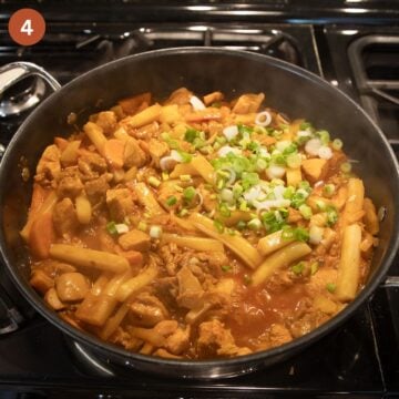 rice cake and chicken stir fry sprinkled with green onions in a saucepan.