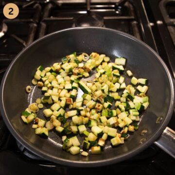 cooking diced zucchini and green onions in a small pan to make omelet.