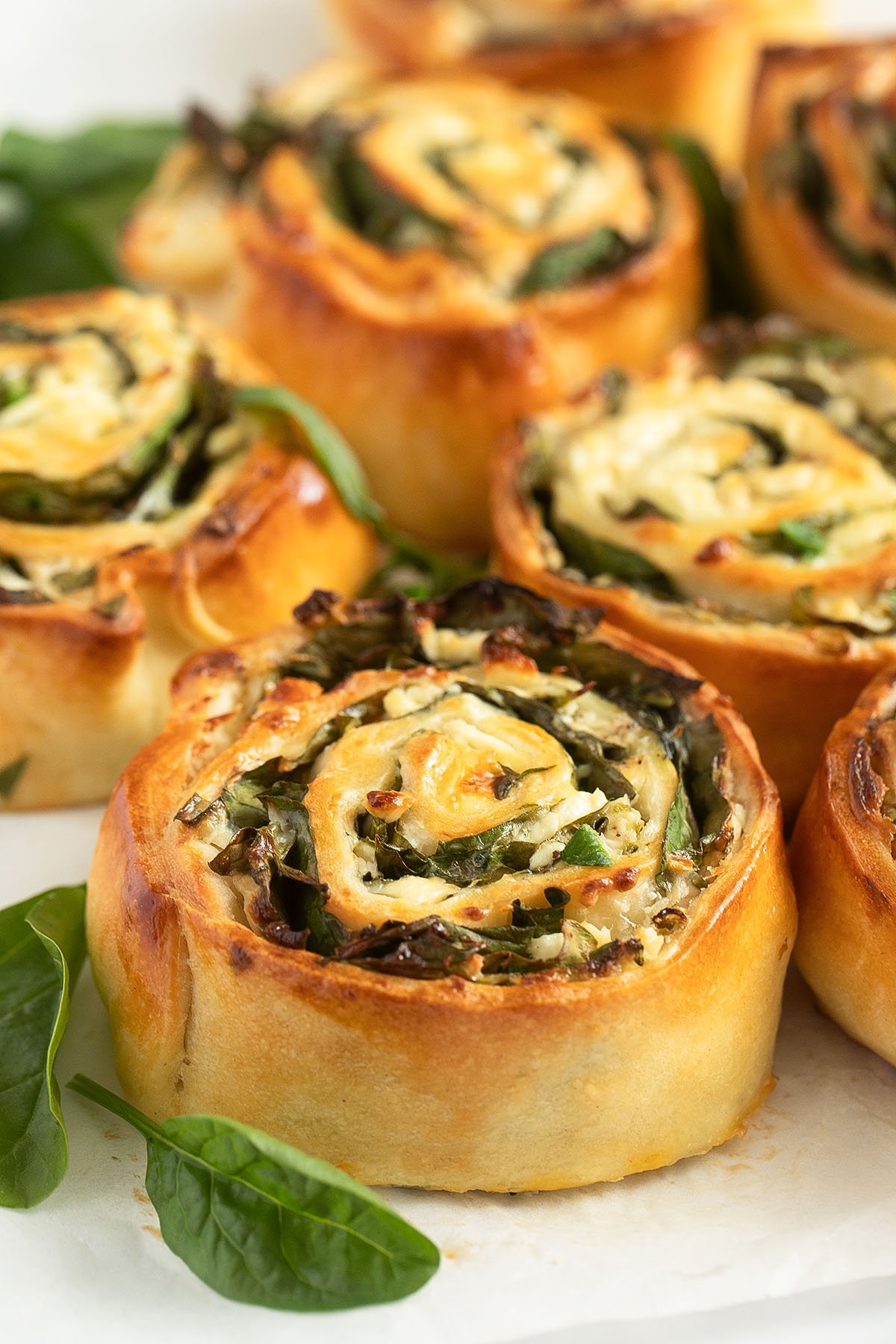 spinach and feta rolls golden baked on the table.