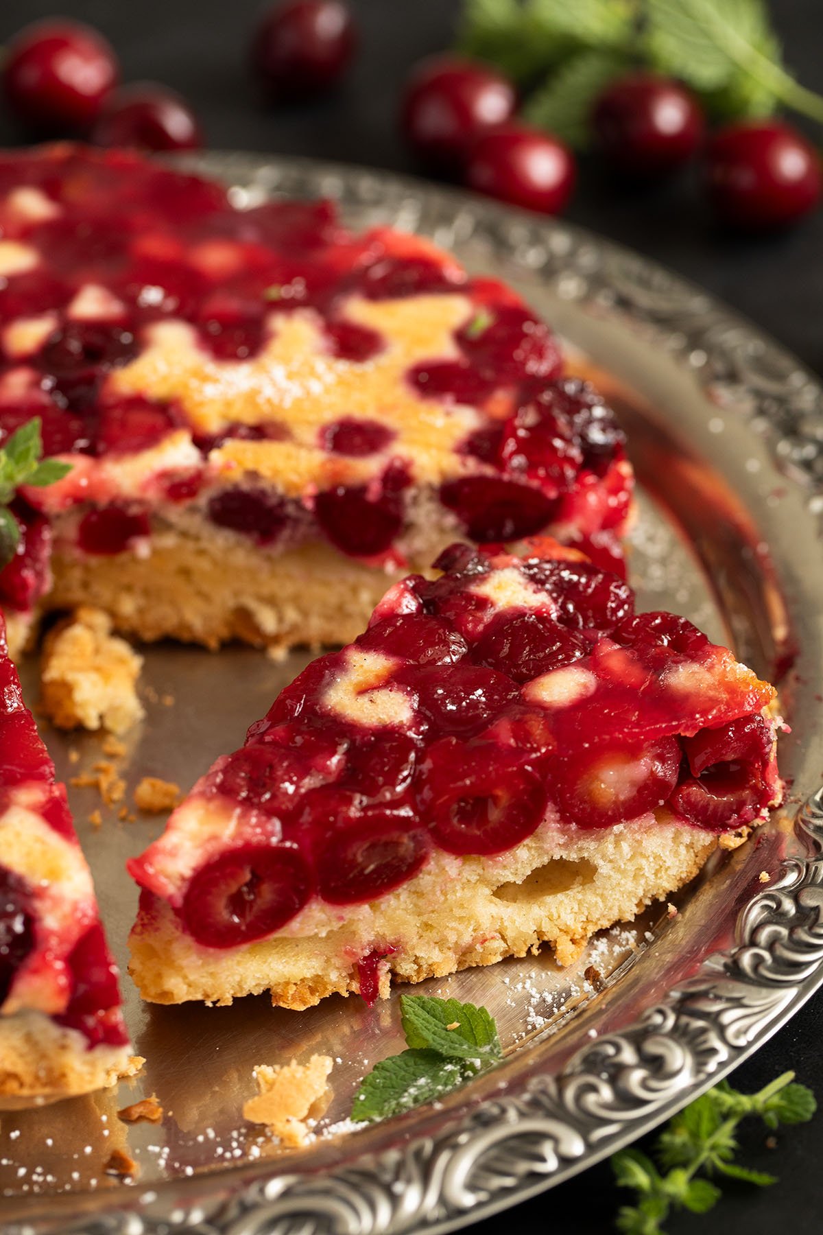 a slice of cherry upside down cake cut from the rest of the cake.